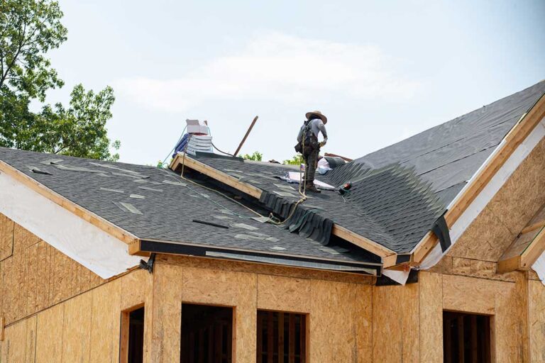 Homeowner viewing damaged shingles and roof edge from the ground with binoculars after a storm.