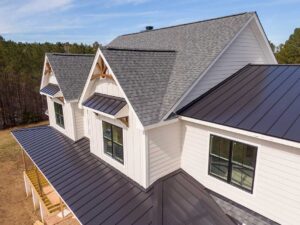 A homeowner uses a soft roof brush from a secured ladder while rinsing leaves from residential shingles. KEYWORDS: ["safe roof cleaning", "roof moss removal", "ladder safety"]