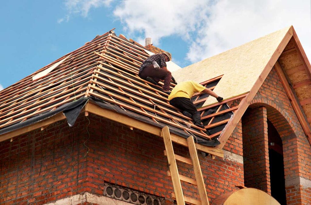 A homeowner examines modern roofing materials, flashing, insulation, and solar-integrated roof components on a worktable.