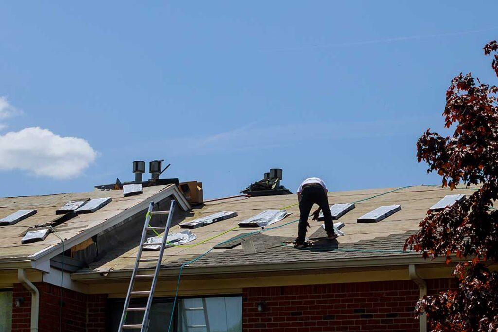 Homeowner reviewing roof edges and gutters from the ground after seasonal weather.