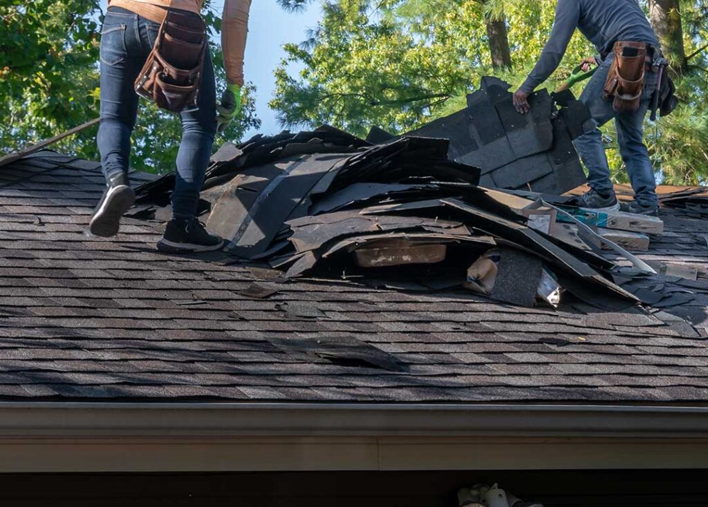 Homeowner inspecting roof edges and gutters from the ground before a heavy rainstorm.