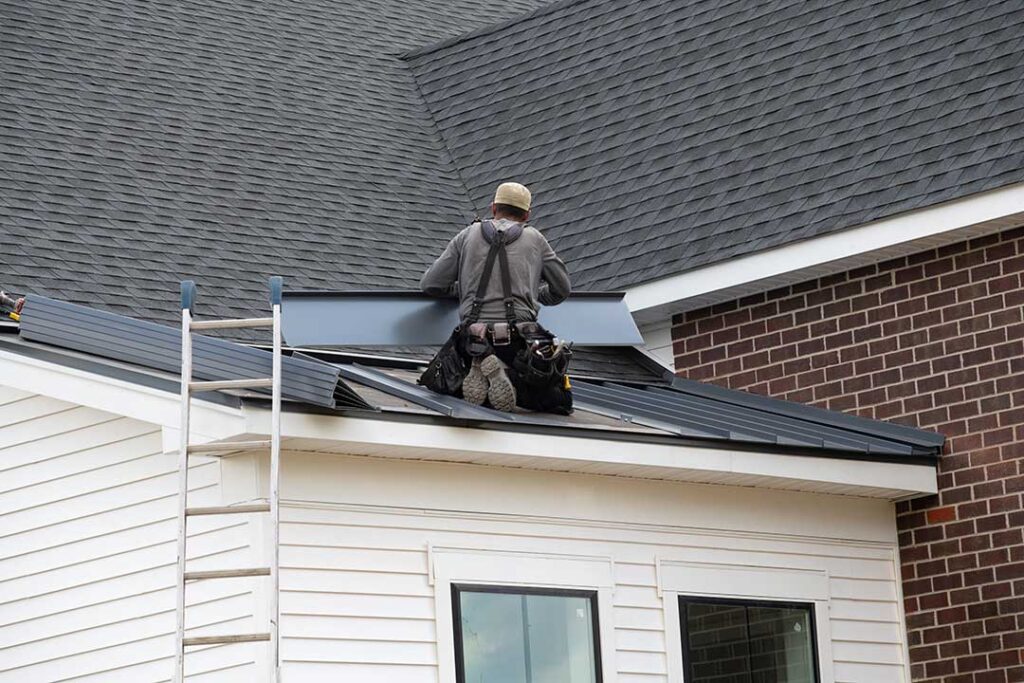 Roof shingles with uneven courses, exposed fasteners, and damaged flashing around a chimney.